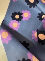Babycord, 100% katoen,  jeansblauwe ondergrond met lila en donkerblauwe bloemen